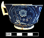 Pearlware London shape handled cup reverse printed underglaze in dark blue. Field dots decorative device forms background behind flowers.  4” rim diameter, 2.5” vessel height.